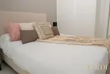 Bed with pink and beige cushions — NOVA interior reference photograph