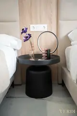 Round bedside table between twin beds — NOVA interior reference photograph